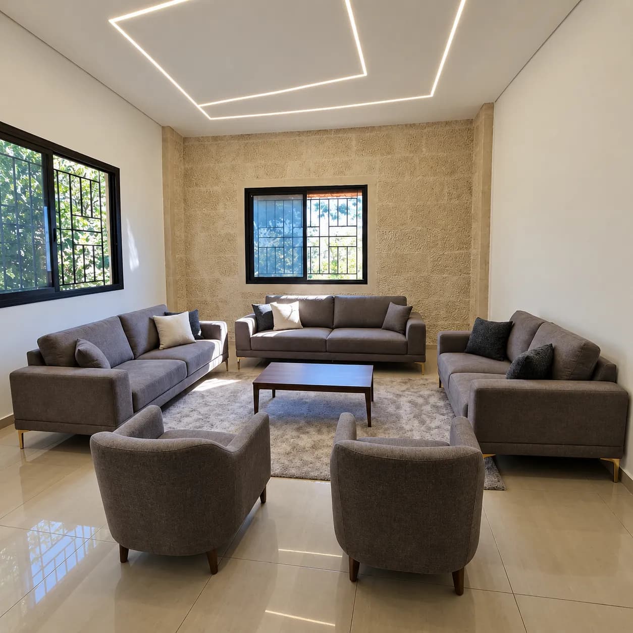 Vesper grey sofas and curved armchairs arranged around a rectangular coffee table